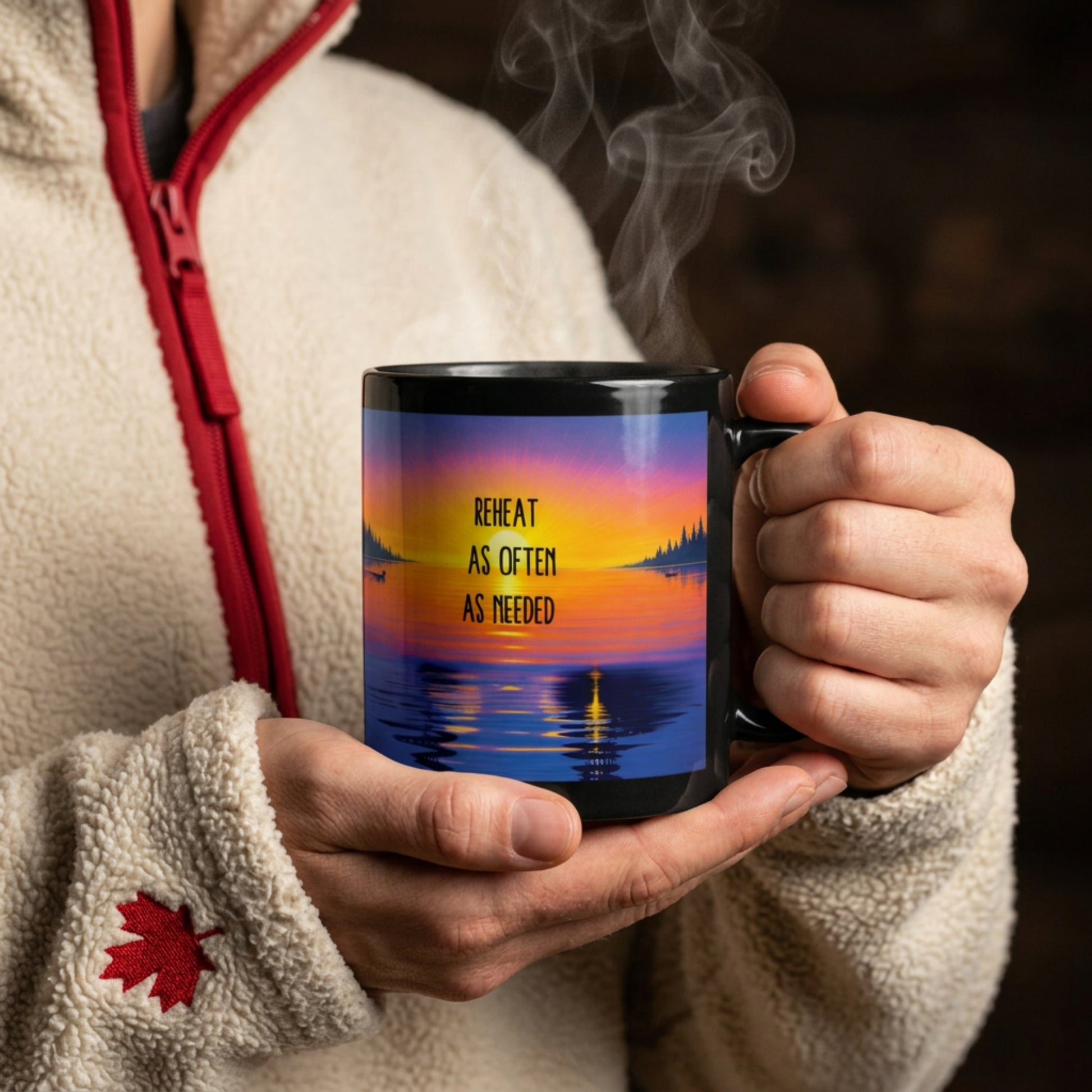hands holding a steaming mug, which has the phrase "reheat as often as needed" with a colorful lake sunrise scene.