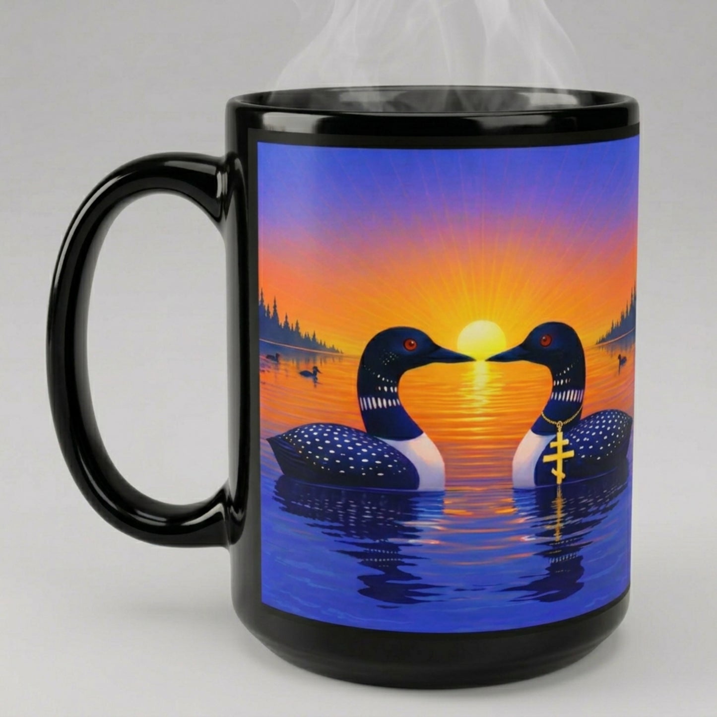 Black ceramic mug with a design of two loons facing each other at sunrise on a lake.