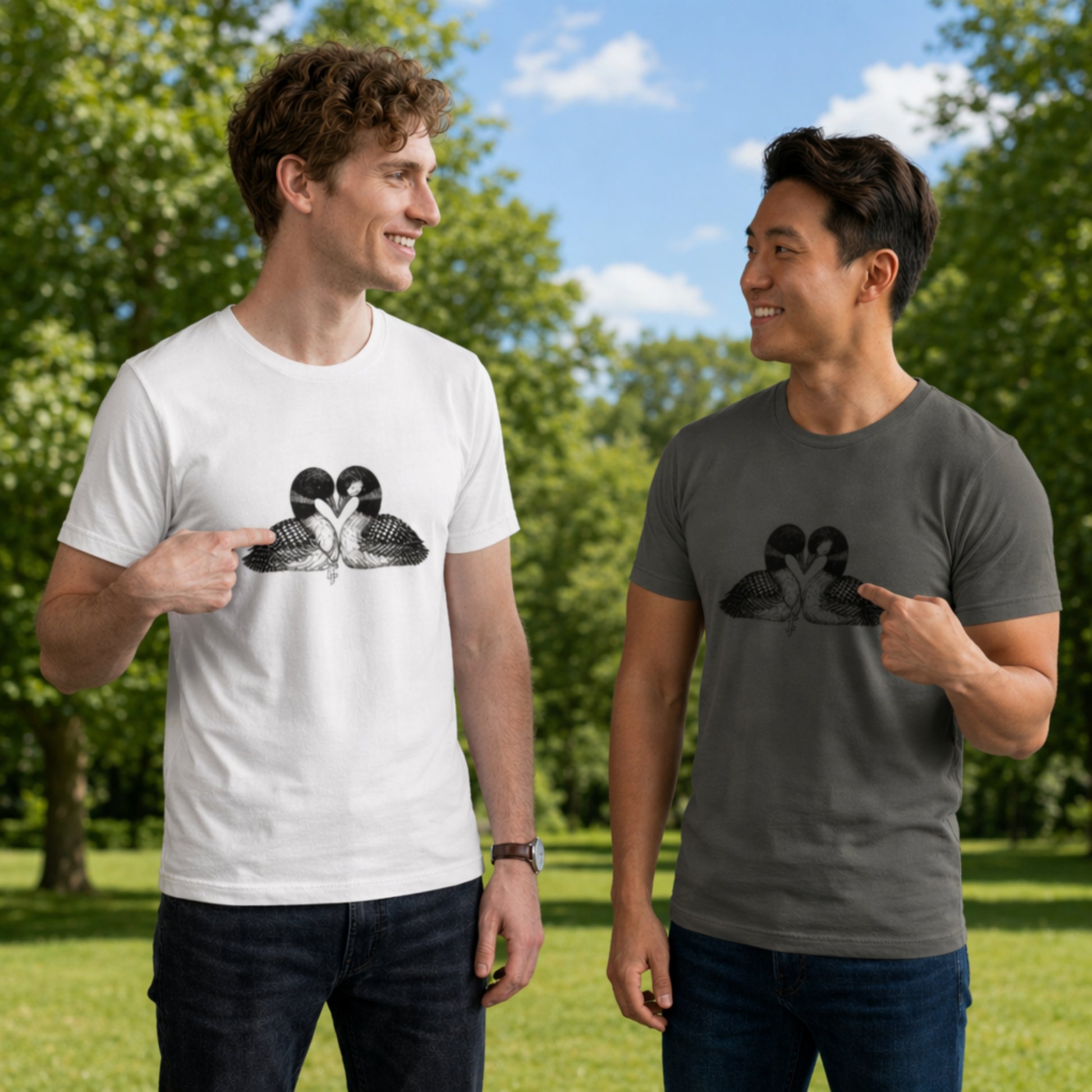 Two men wearing hockey romance loon t-shirts with two loons graphic design outdoors on a sunny day. Each is pointing to the loon that represents them (based on characters from a popular book and series)