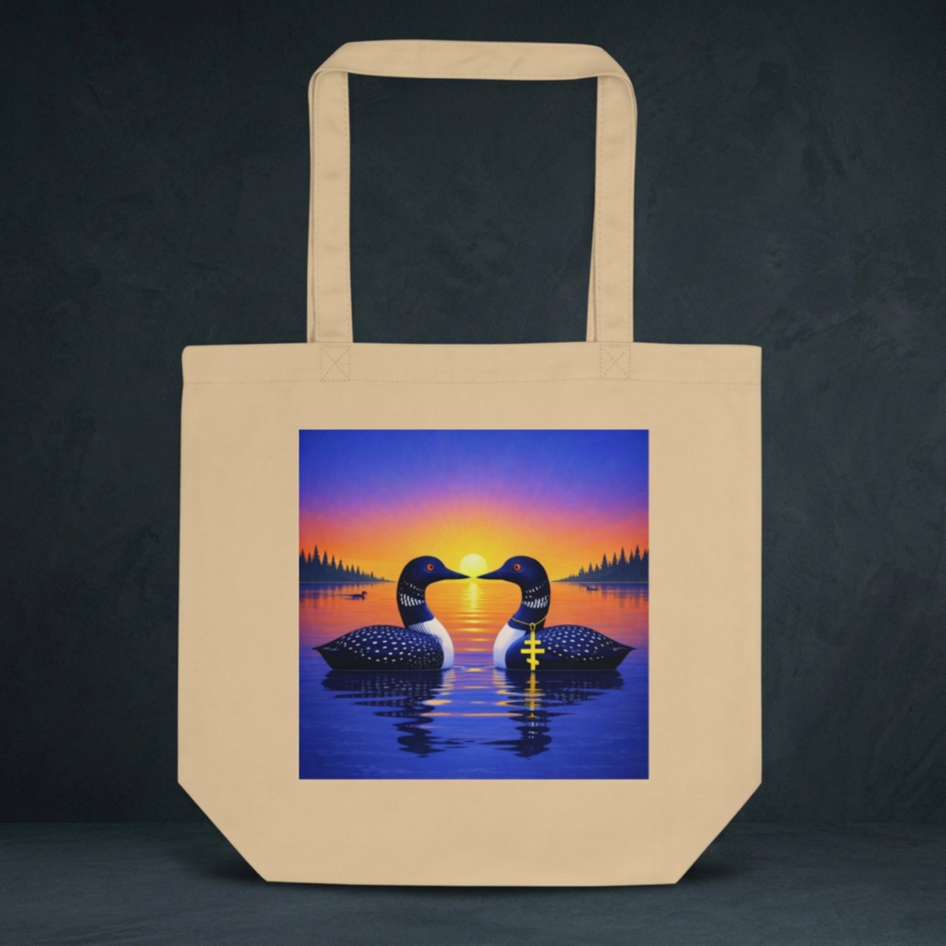 natural colored tote bag with design of two loons on lake at sunrise.