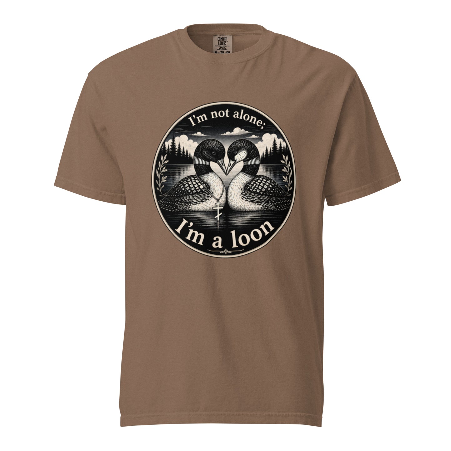 An Espresso colored short-sleeve crewneck t-shirt featuring a circular black and white graphic of two loons facing each other in front of a lake and mountains, with the text 'I'm not alone. I'm a loon'.