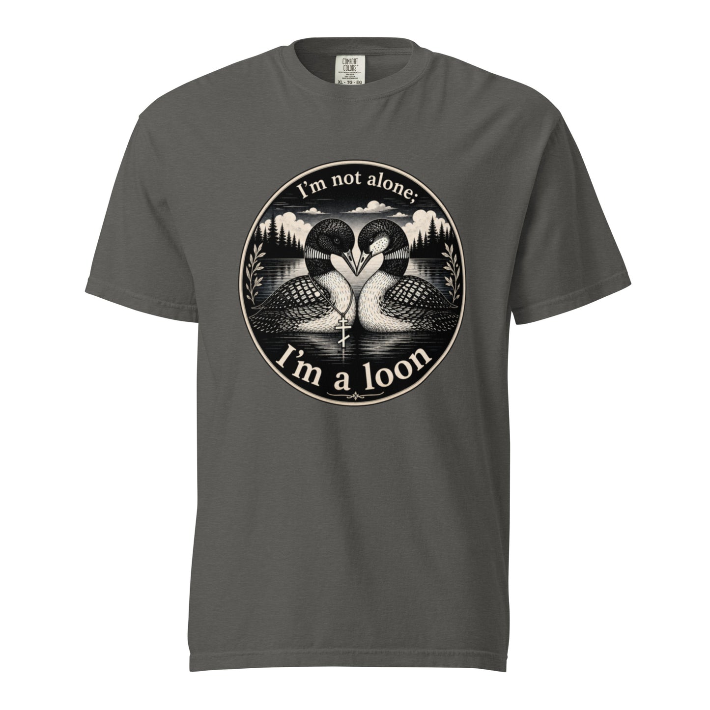 A Pepper colored short-sleeve crewneck t-shirt featuring a circular black and white graphic of two loons facing each other in front of a lake and mountains, with the text 'I'm not alone. I'm a loon'.