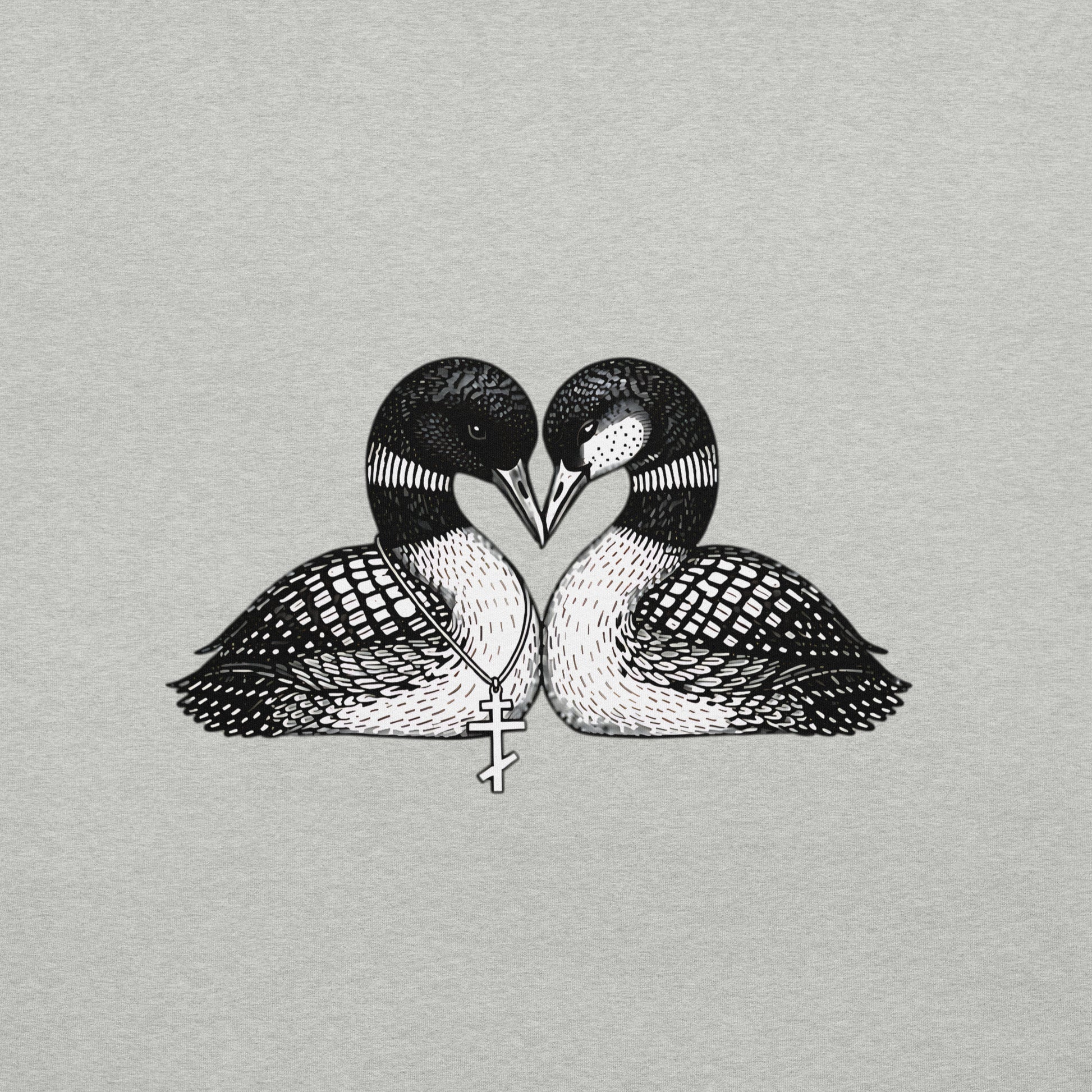 Close view of graphic on a hockey romance loon t-shirt. It has two loons, touching beaks to form a heart shape and one loon has freckles and the other one is wearing a Russian orthodox cross around it's neck- both brids refer to main characters in a popular romance book series and tv show. Shirt color is Athletic Heather