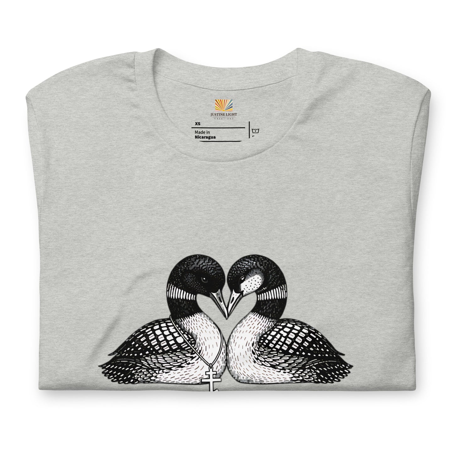 Folded image of hockey romance loon t-shirt with a graphic of two birds, with beaks together forming a heart. Athletic Heather color shirt