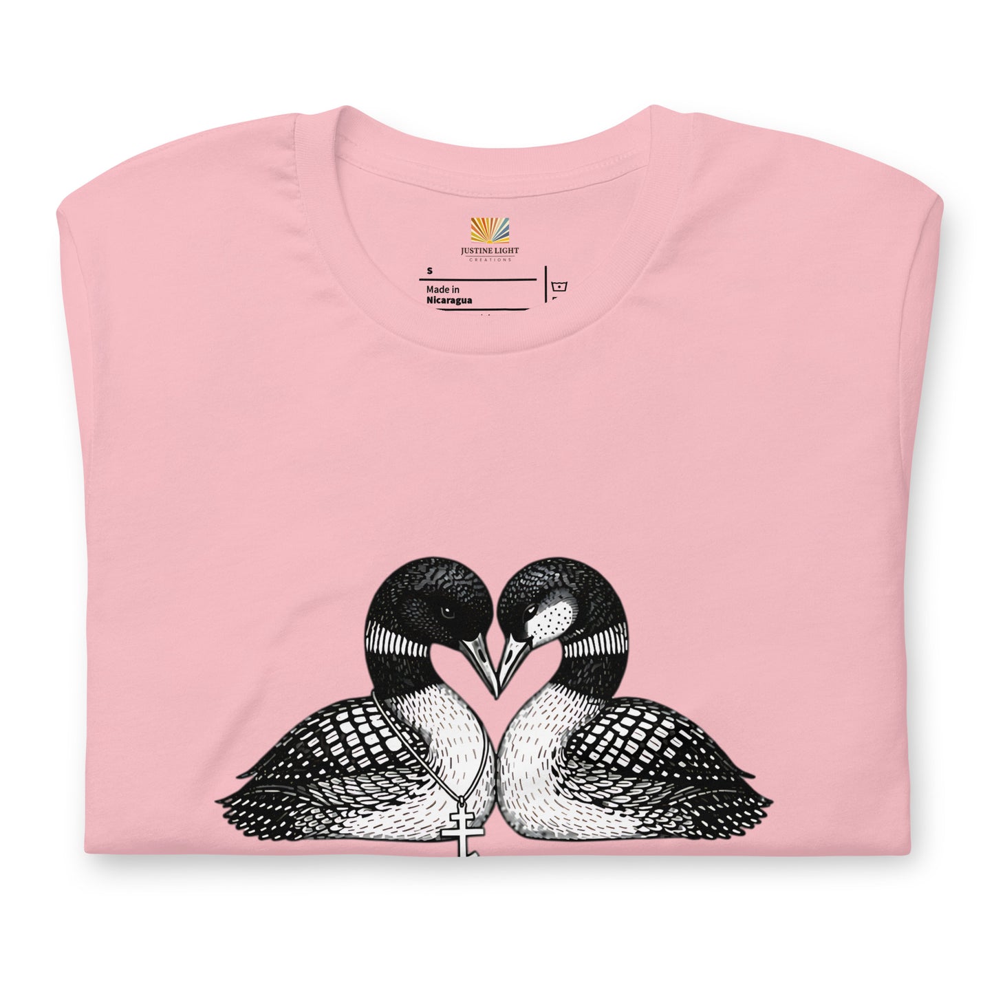 Folded image of hockey romance loon t-shirt with a graphic of two birds, with beaks together forming a heart. Pink color shirt