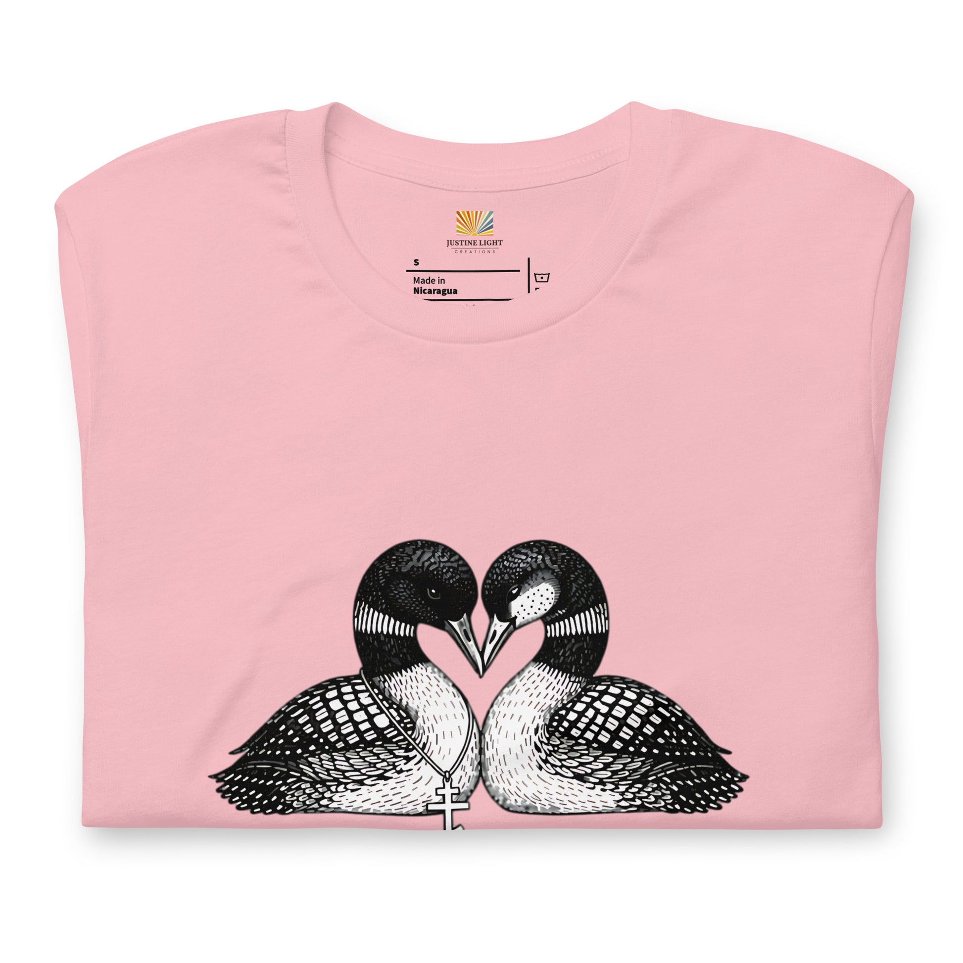 Folded image of hockey romance loon t-shirt with a graphic of two birds, with beaks together forming a heart. Pink color shirt
